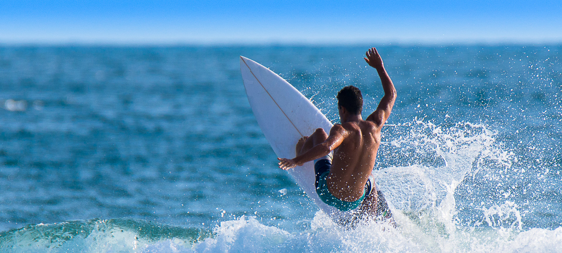 Surfer bei einer 180º-Drehung auf der Welle